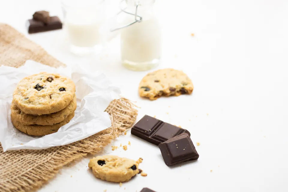 Cookies et carrés de chocolat sur une table blanche